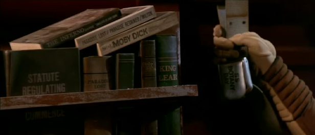 Khan's bookshelf. Titles include Statute Regulating, Dante's Inferno, King Lear, Moby Dick, the Bible, and 2 copies of Paradise Lost